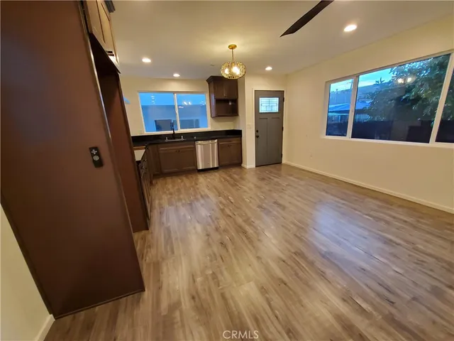 an open kitchen with a sink and dishwasher with wooden floor