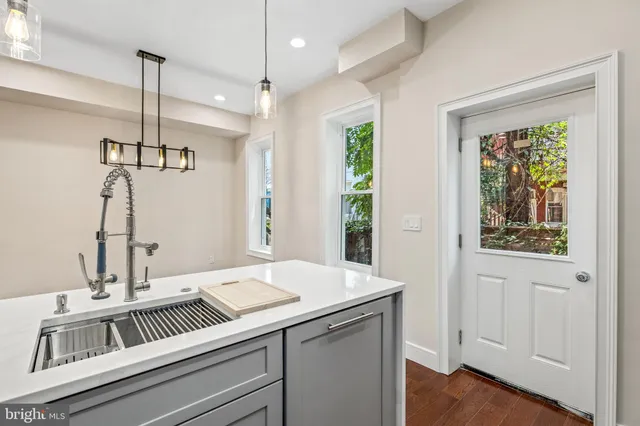 a view of a sink and dishwasher with wooden floor