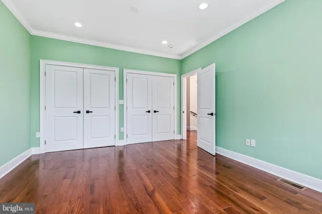 a view of an empty room with wooden floor