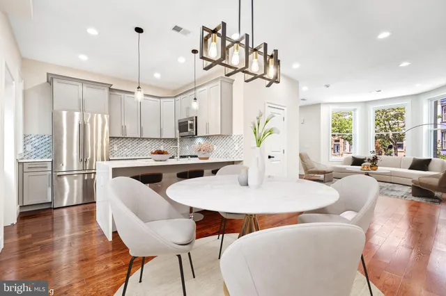 a large kitchen with a table chairs refrigerator and microwave