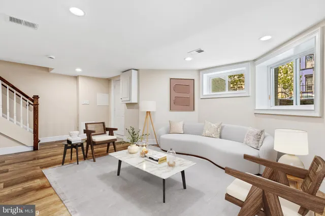 a living room with furniture a rug and a window