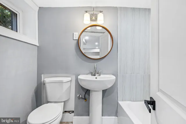 a bathroom with a sink a toilet and mirror