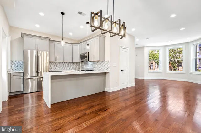 a view of a kitchen with wooden floor and window