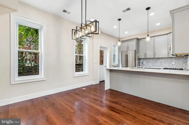 a view of a kitchen with wooden floor and windows