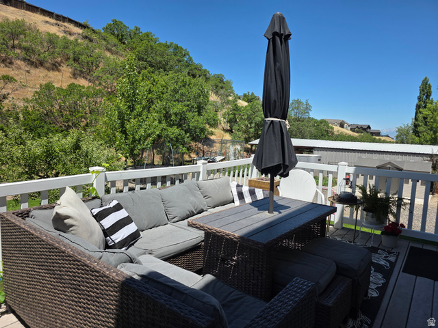387 North Loafer Canyon Road Payson, UT 84651 - Photo 64 of 94 Spacious outdoor deck featuring light-colored railing, gray composite decking, and a backdrop of green foliage and distant hills