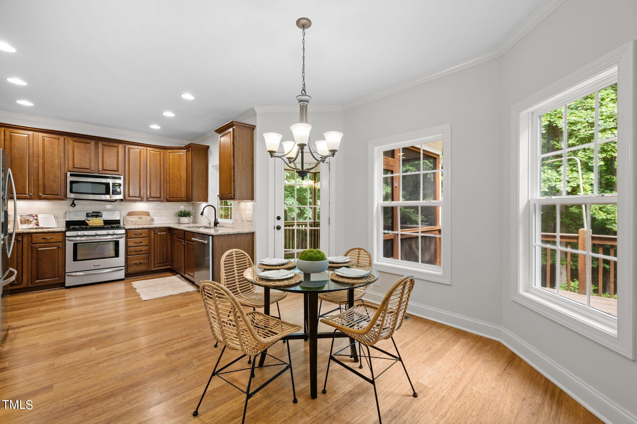 152 Roads End Pittsboro, NC 27312 - Photo 17 of 58 a kitchen with stainless steel appliances granite countertop wooden floor a refrigerator a stove a sink dishwasher a dining table and chairs with wooden floor