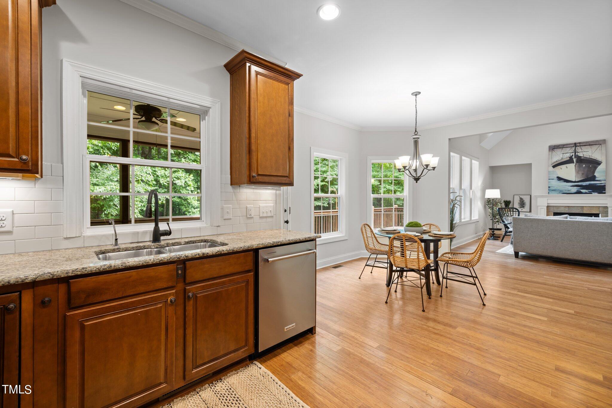 152 Roads End Pittsboro, NC 27312 - Photo 18 of 58 a kitchen with stainless steel appliances granite countertop wooden floor sink stove and dining table
