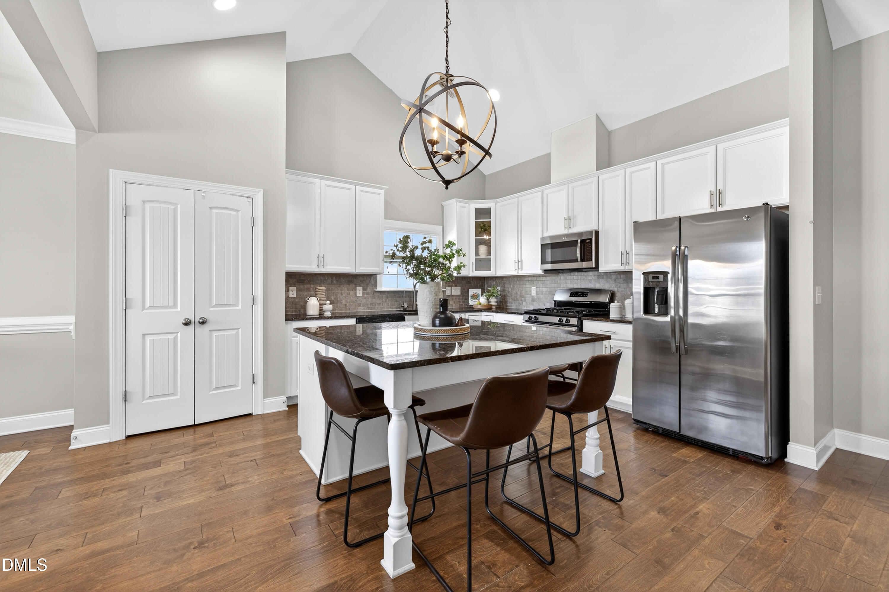 5248 Copain Cove Fuquay-Varina, NC 27526 - Photo 11 of 47 a kitchen with stainless steel appliances granite countertop a dining table chairs refrigerator and cabinets