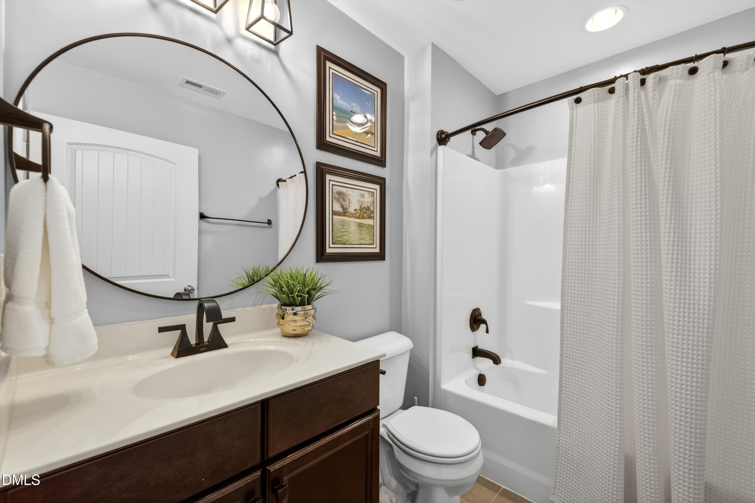 5248 Copain Cove Fuquay-Varina, NC 27526 - Photo 25 of 47 a bathroom with a sink toilet a mirror and shower
