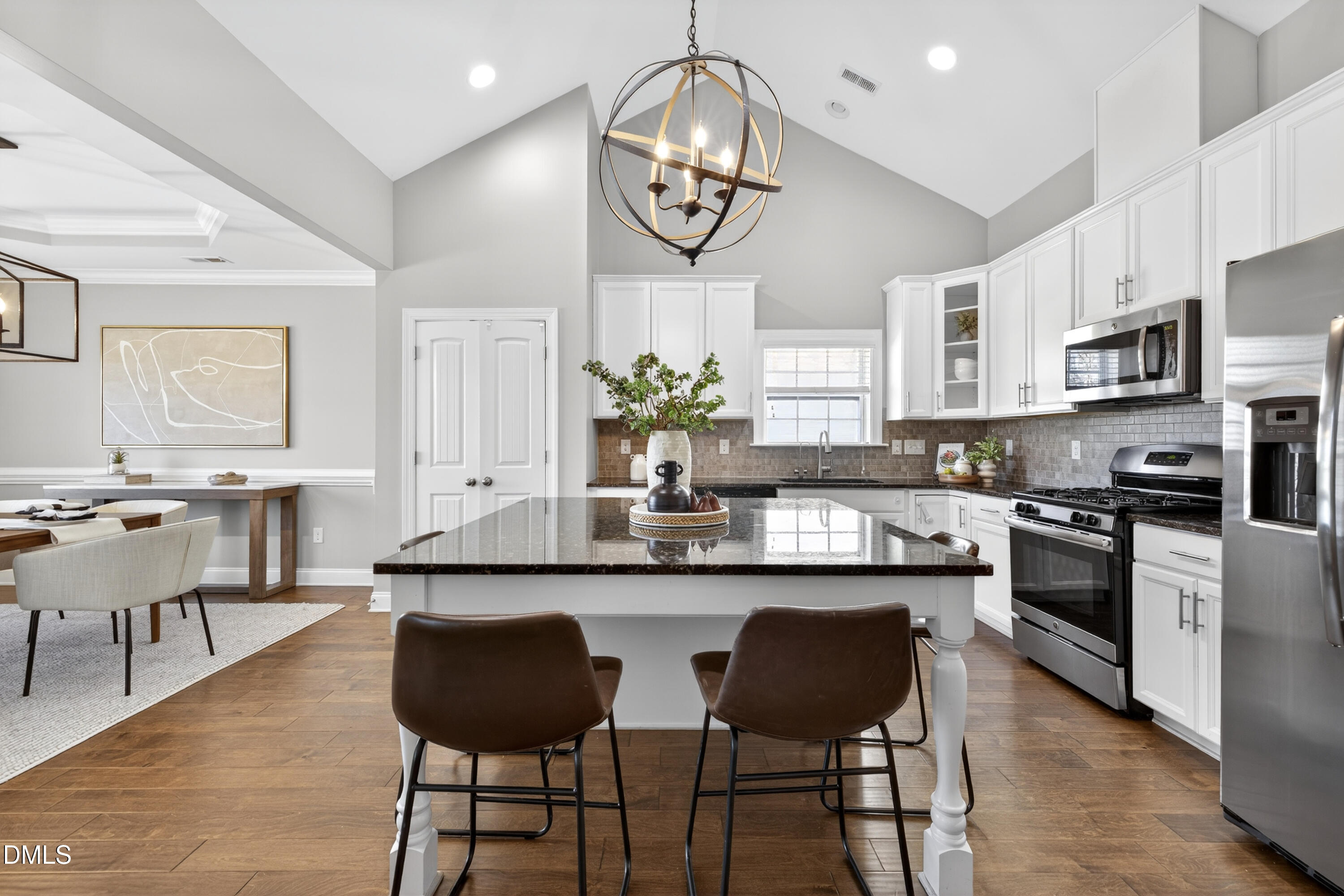 5248 Copain Cove Fuquay-Varina, NC 27526 - Photo 4 of 47 a kitchen with stainless steel appliances granite countertop a stove top oven a sink dishwasher and a dining table with wooden floor