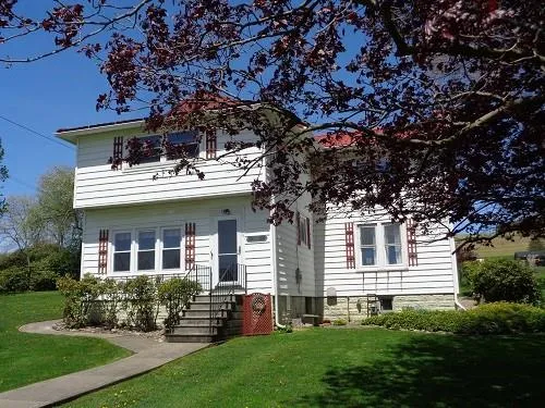 a front view of a house with a garden and yard