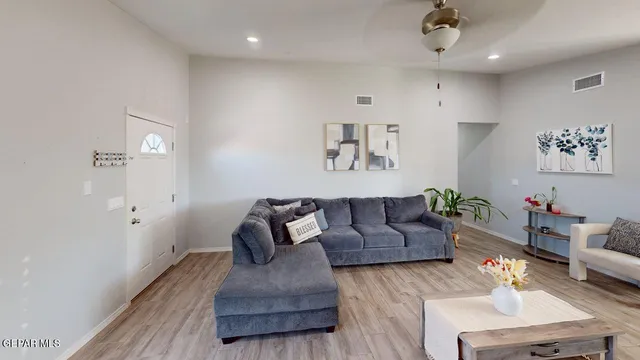 a living room with furniture and a wooden floor