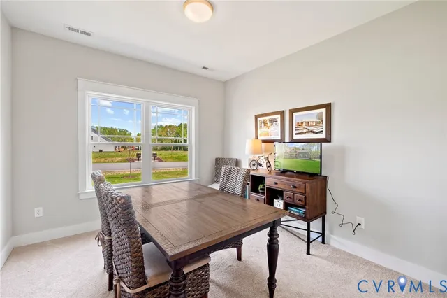 a view of a dining room with furniture a rug and wooden floor