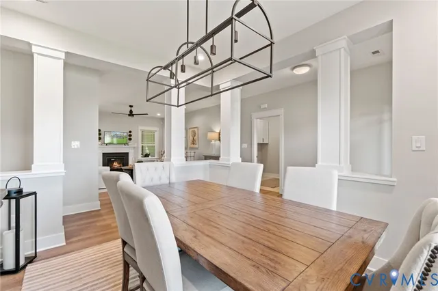 a view of a dining room and livingroom with furniture wooden floor a chandelier