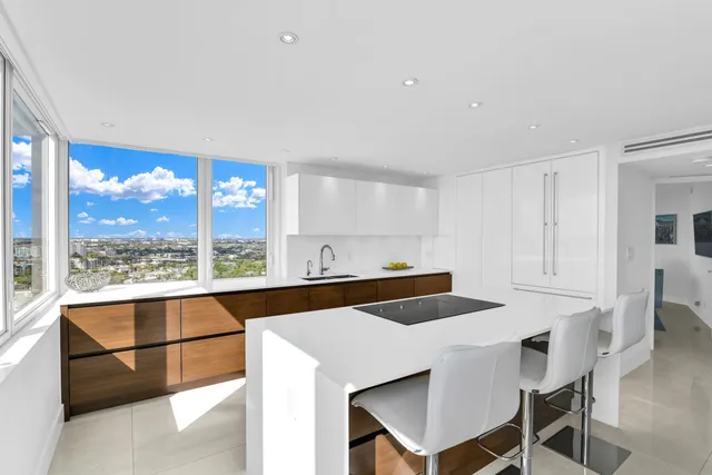 a room with stainless steel appliances kitchen island granite countertop a table chairs stove and kitchen view