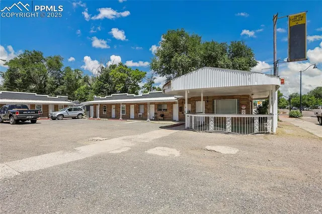 a front view of a house with a garden and trees