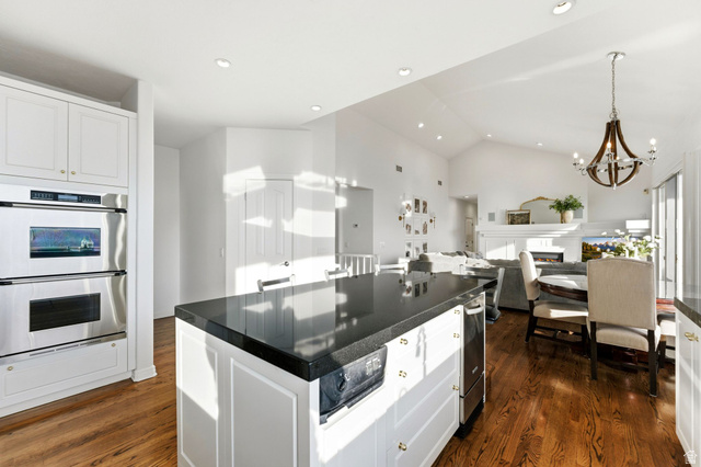 1878 East Ridge Point Drive Bountiful, UT 84010 - Photo 15 of 92 Kitchen featuring dark countertops, white cabinetry, stainless steel double oven, dark wood-style floors, and vaulted ceiling