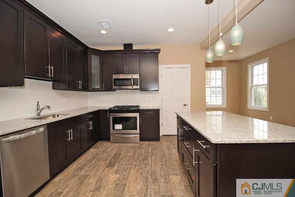 1035 New Durham Road Edison, NJ 08817 - Photo 11 of 24 a kitchen with kitchen island granite countertop a sink dishwasher stove and cabinets