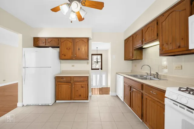 a kitchen with stainless steel appliances granite countertop a refrigerator sink and stove