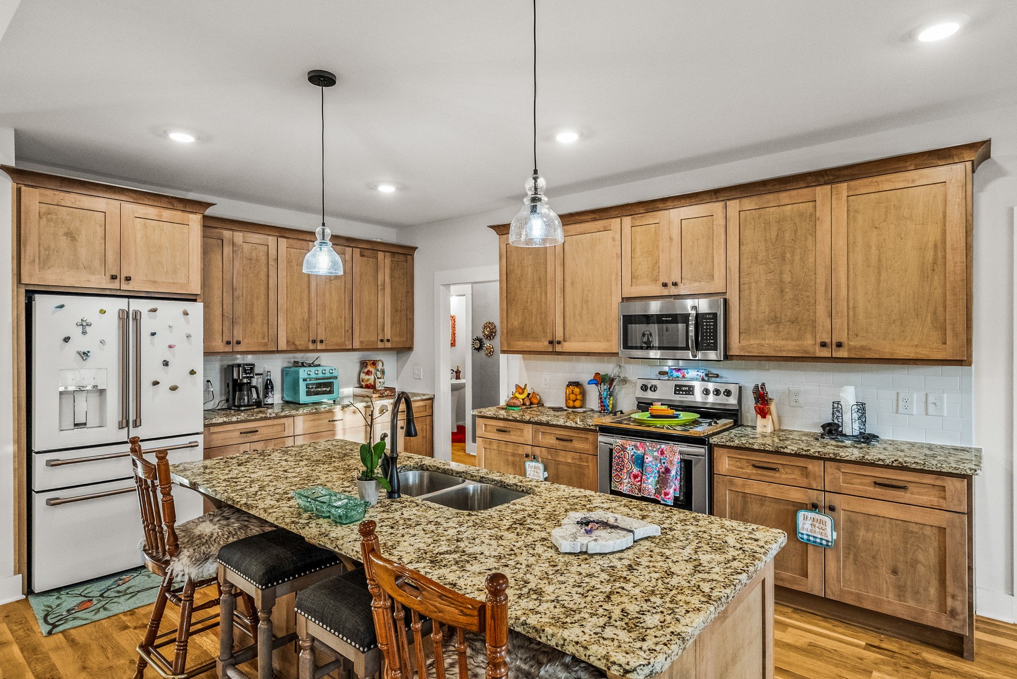 3378 New Hall Road Greenbrier, TN 37073 - Photo 30 of 83 a kitchen with stainless steel appliances granite countertop a stove top oven a refrigerator a sink a dining table and chairs with wooden floor