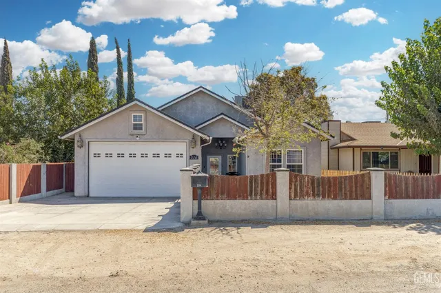 a front view of a house with a yard covered in snow