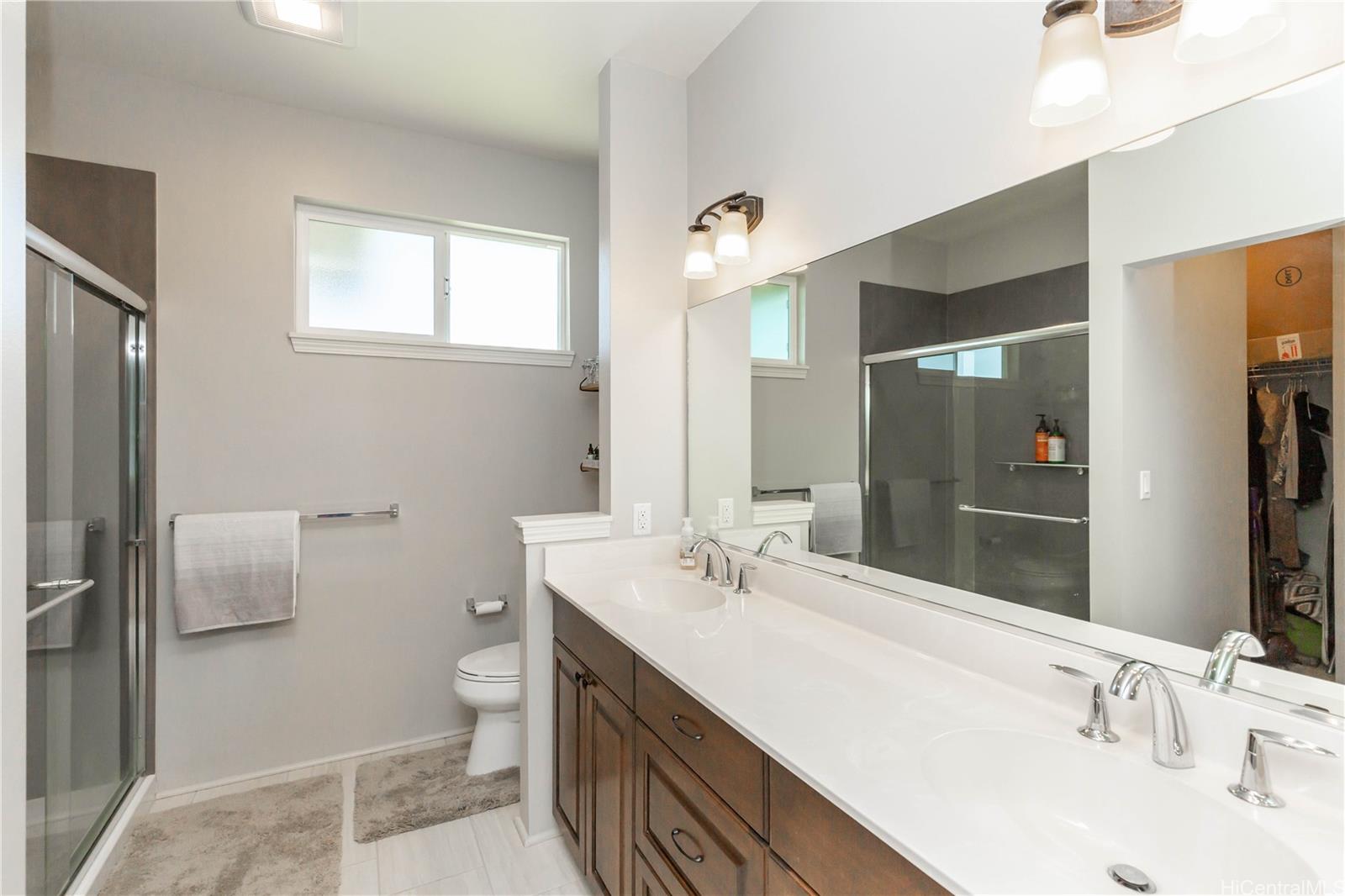 91-1077 Hokua Street Ewa Beach, HI 96706 - Photo 11 of 25 a bathroom with a double vanity sink toilet and mirror