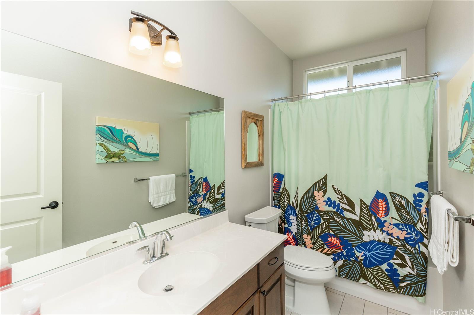 91-1077 Hokua Street Ewa Beach, HI 96706 - Photo 12 of 25 a bathroom with a sink mirror and toilet