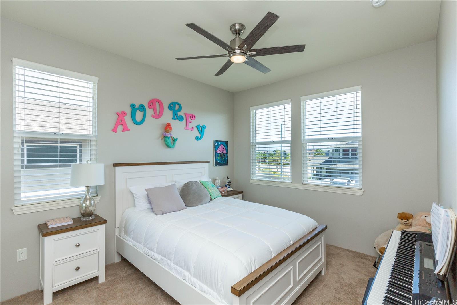 91-1077 Hokua Street Ewa Beach, HI 96706 - Photo 13 of 25 a bedroom with a bed and a chandelier
