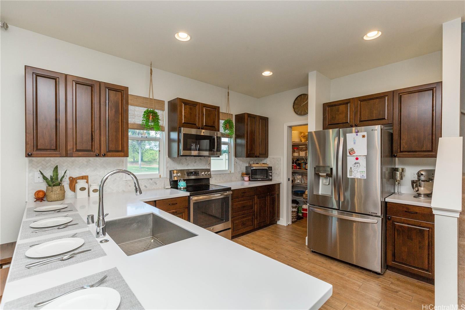 91-1077 Hokua Street Ewa Beach, HI 96706 - Photo 5 of 25 a kitchen with stainless steel appliances granite countertop a refrigerator stove microwave and sink