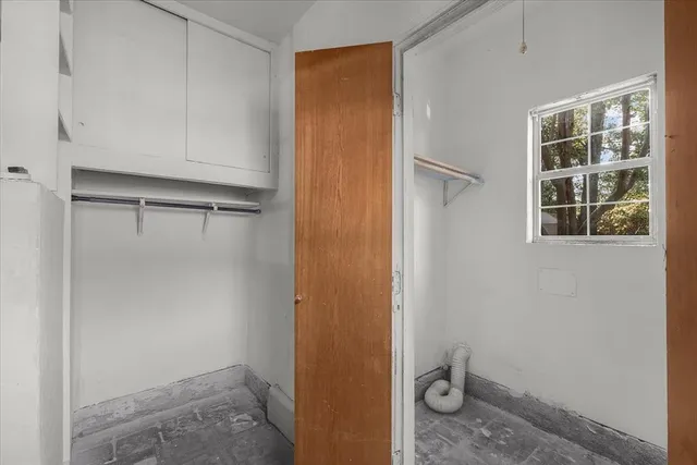 an empty room with a window and ceiling fan