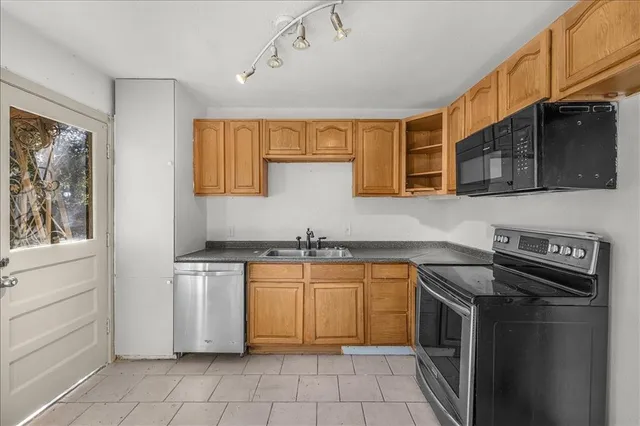a kitchen with stainless steel appliances granite countertop a sink and a stove