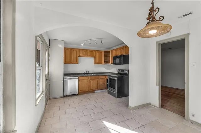 a kitchen with stainless steel appliances granite countertop a refrigerator and a sink