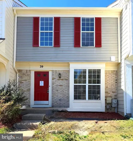 a front view of a building with a yard and barbeque oven