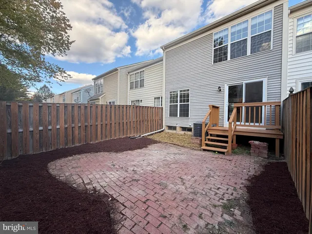 a view of backyard with wooden fence and a large tree
