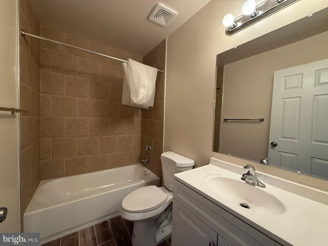 a bathroom with a sink mirror toilet and bathtub