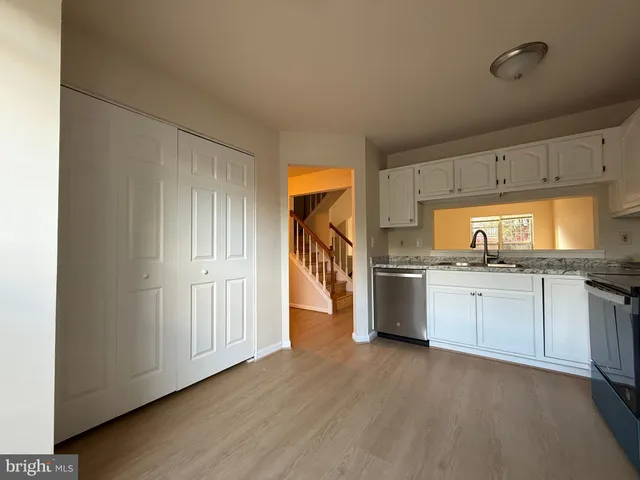 a kitchen with granite countertop white cabinets and stainless steel appliances