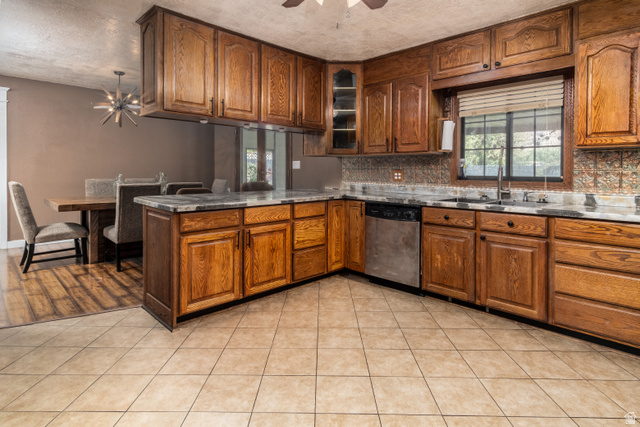 100 Third North Helper, UT 84526 - Photo 18 of 30 Kitchen featuring wood cabinetry, stone countertops, stainless steel dishwasher, and a patterned tile backsplash