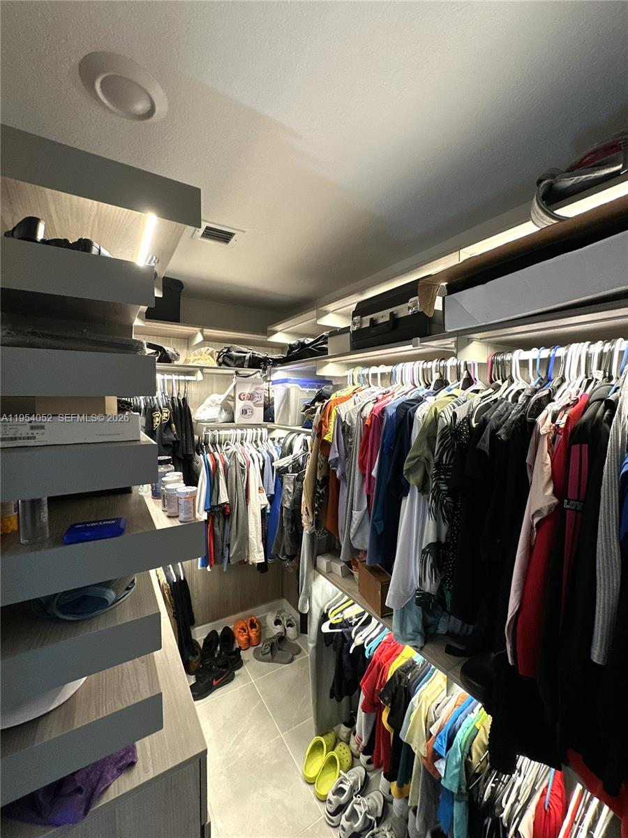 13321 Southwest 284th Street Homestead, FL 33033 - Photo 12 of 30 a view of walk in closet with clothes and shoes