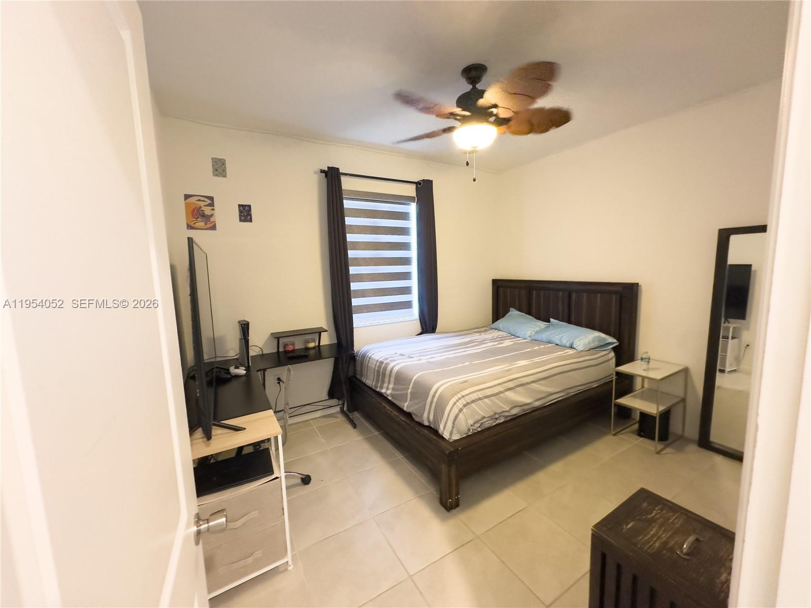 13321 Southwest 284th Street Homestead, FL 33033 - Photo 18 of 30 a bedroom with a bed and a chandelier