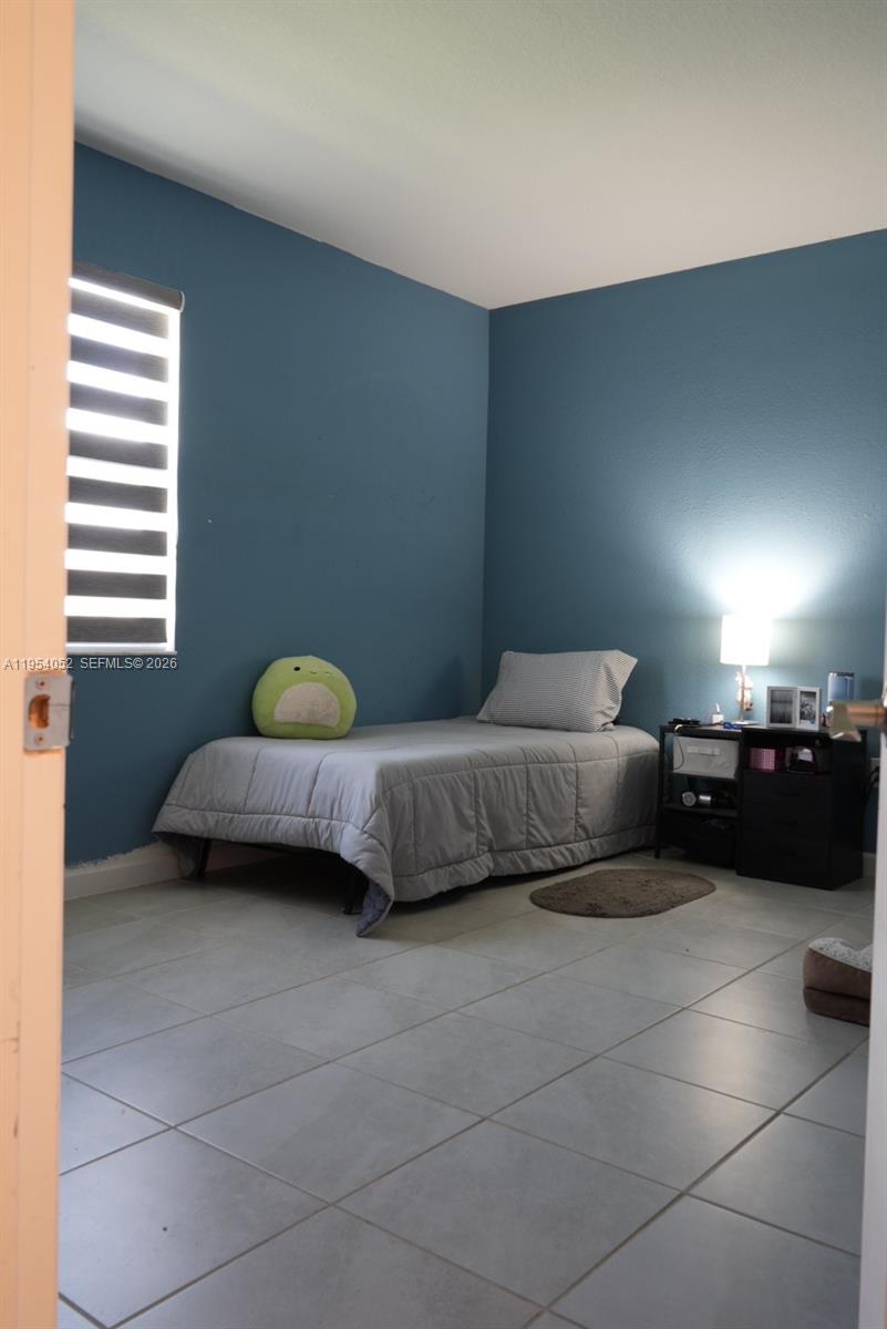 13321 Southwest 284th Street Homestead, FL 33033 - Photo 20 of 30 a bedroom with a bed and a couch