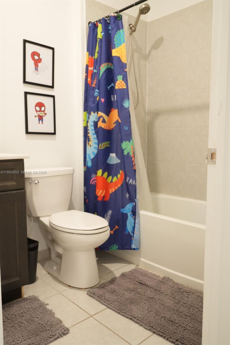 13321 Southwest 284th Street Homestead, FL 33033 - Photo 21 of 30 a bathroom with a toilet and a shower curtain