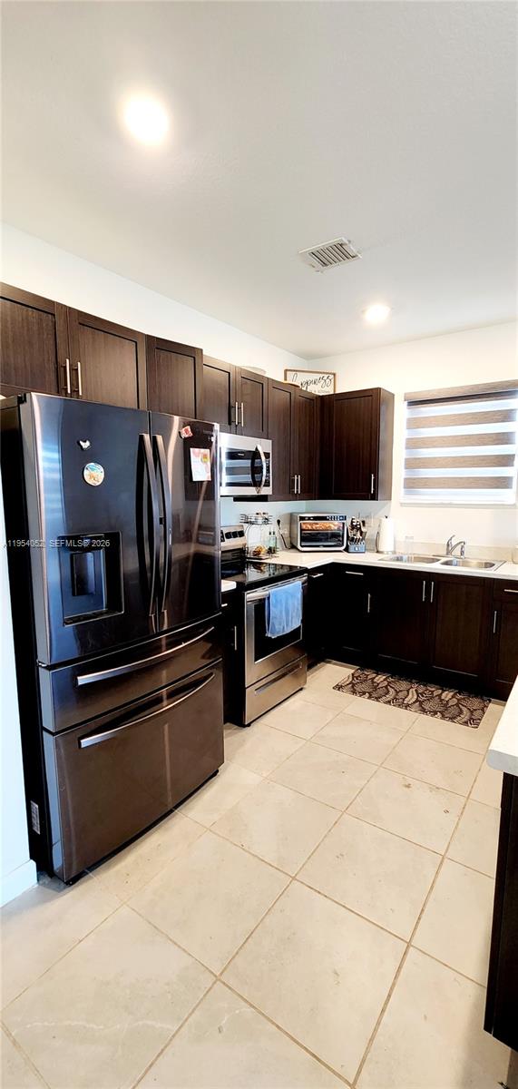 13321 Southwest 284th Street Homestead, FL 33033 - Photo 6 of 30 a kitchen with stainless steel appliances a sink and a refrigerator
