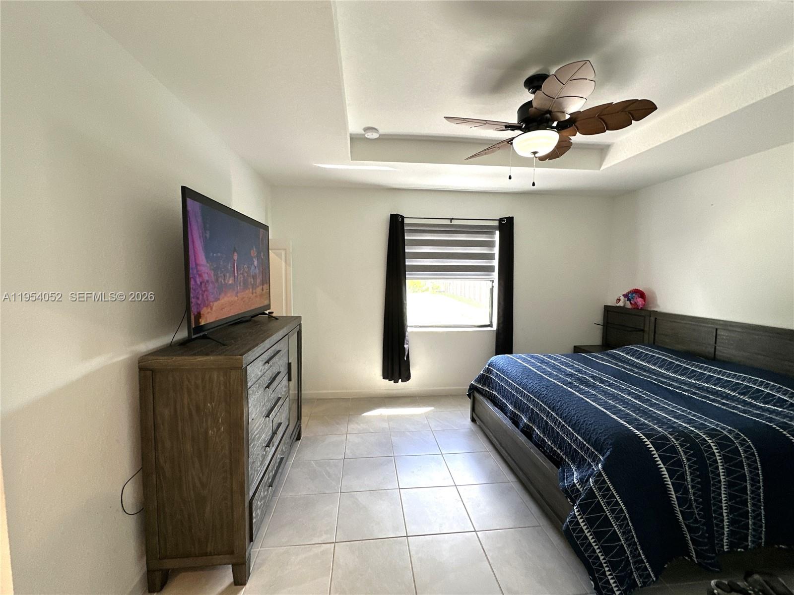 13321 Southwest 284th Street Homestead, FL 33033 - Photo 10 of 30 a bedroom with a bed and a flat screen tv