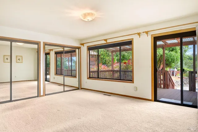 an empty room with sliding glass door and mountain view