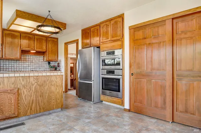 a kitchen with stainless steel appliances granite countertop a refrigerator and a sink
