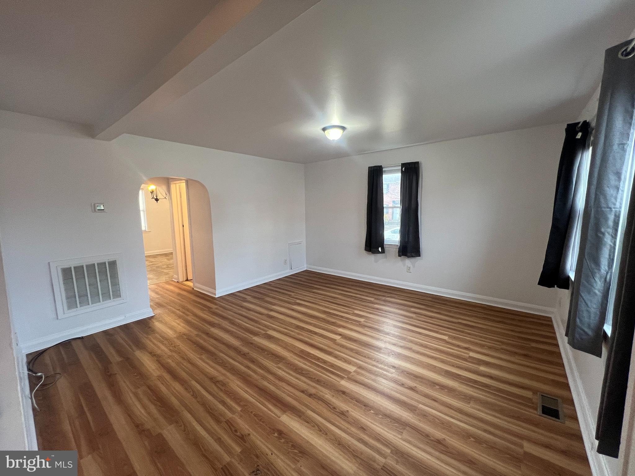 2900 Cornwall Road Baltimore, MD 21222 - Photo 2 of 17 a view of an empty room with wooden floor and a window