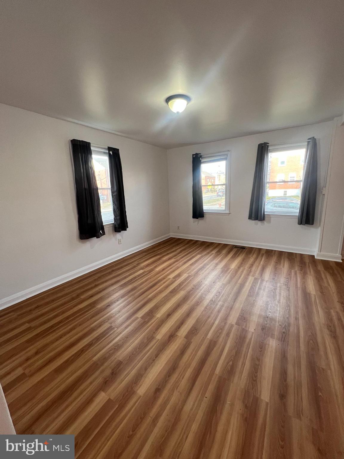 2900 Cornwall Road Baltimore, MD 21222 - Photo 4 of 17 an empty room with wooden floor and windows