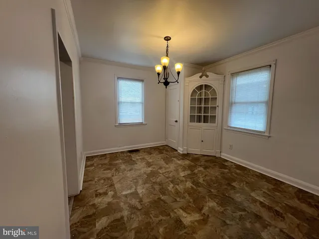 an empty room with windows and chandelier
