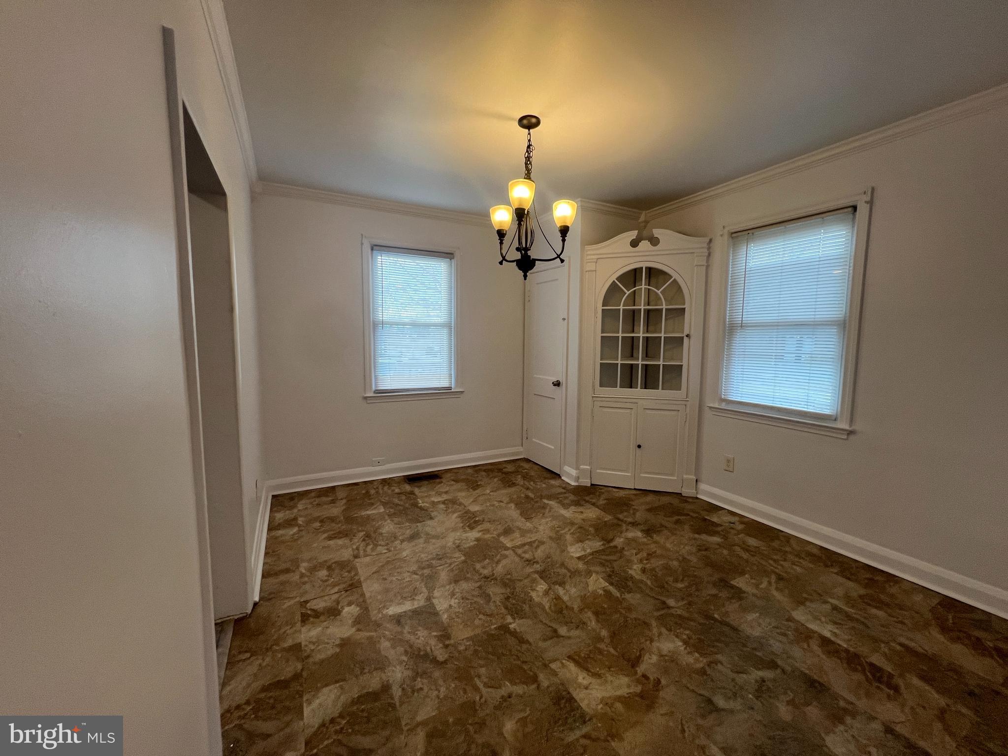2900 Cornwall Road Baltimore, MD 21222 - Photo 6 of 17 an empty room with windows and chandelier