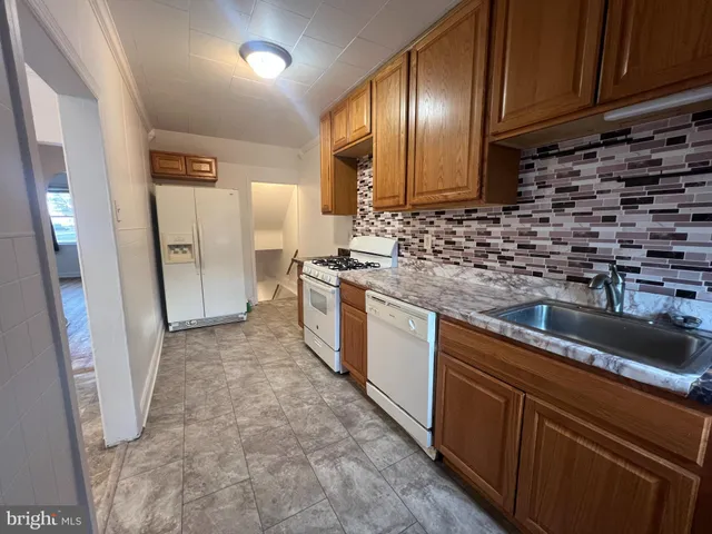 a kitchen with granite countertop a sink stove and cabinets